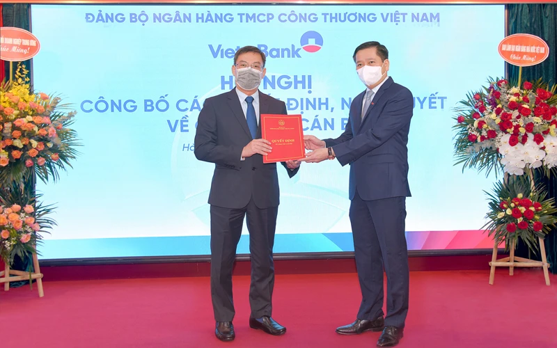 Ủy viên Dự khuyết Trung ương Đảng Nguyễn Long Hải trao quyết định và tặng hoa chúc mừng đồng chí Trần Minh Bình.