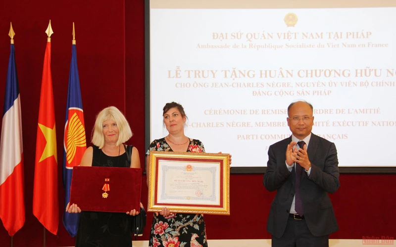 Đại sứ Đinh Toàn Thắng trao tặng Huân chương Hữu nghị cho vợ và con gái đồng chí Jean-Charles Nègre. (Ảnh: KHẢI HOÀN - ĐÌNH TUẤN).