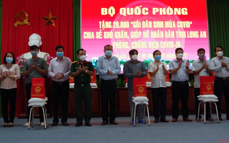Đại diện Bộ Quốc phòng trao quà cho người lao động khó khăn trên địa bàn huyện Châu Thành (Long An). (Ảnh: THANH PHONG).