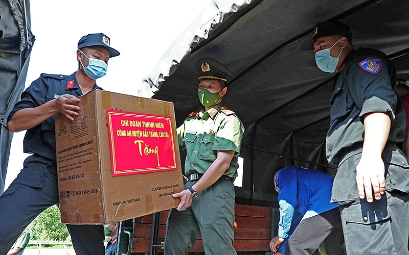 Các chiến sĩ trẻ tình nguyện của lực lượng Công an TP Hà Nội và tỉnh Lào Cai vận chuyển trang thiết bị y tế, nhu yếu phẩm hỗ trợ Thủ đô chống dịch.