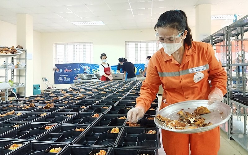 Những người thợ điện trong đồng phục màu cam đặc trưng chuẩn bị các suất ăn gửi tặng đồng bào có hoàn cảnh khó khăn.