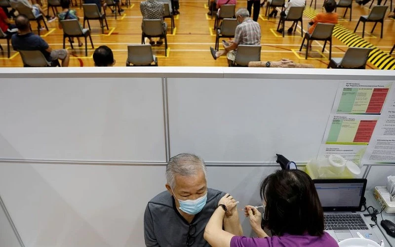 Tiêm vaccine ngừa Covid-19 ở Singapore. (Ảnh: Reuters)