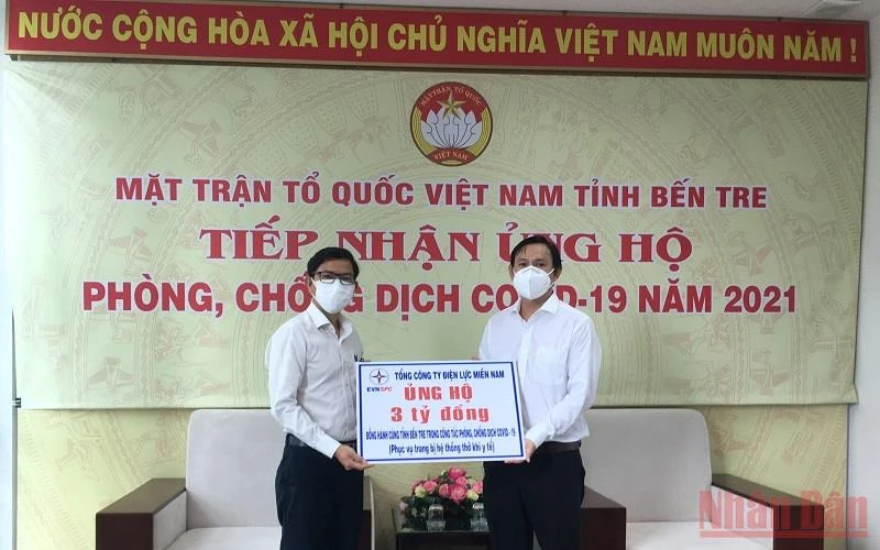 Quyền Chủ tịch Ủy ban Mặt trận Tổ quốc Việt Nam tỉnh Bến Tre Nguyễn Phúc Linh (phải) nhận bảng tượng trưng số tiền 3 tỷ đồng hỗ trợ tỉnh Bến Tre.