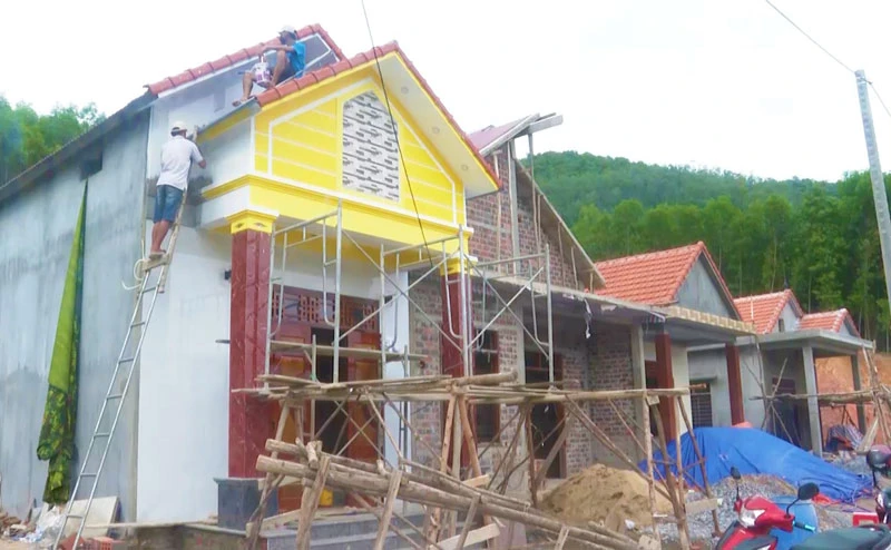 Người dân xã Thạch Hóa, huyện Tuyên Hóa hoàn thiện những công đoạn cuối để đưa nhà mới vào ở.