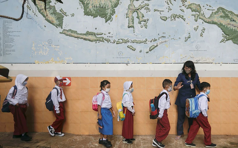 Học sinh tiểu học ở Indonesia tuân thủ các biện pháp phòng dịch. Ảnh Reuters