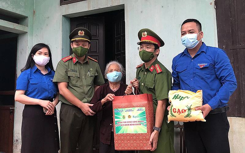 Đoàn công tác của thanh niên Công an Thủ đô trao quà tặng người già neo đơn tại xã Kim Nỗ, huyện Đông Anh (Hà Nội).
