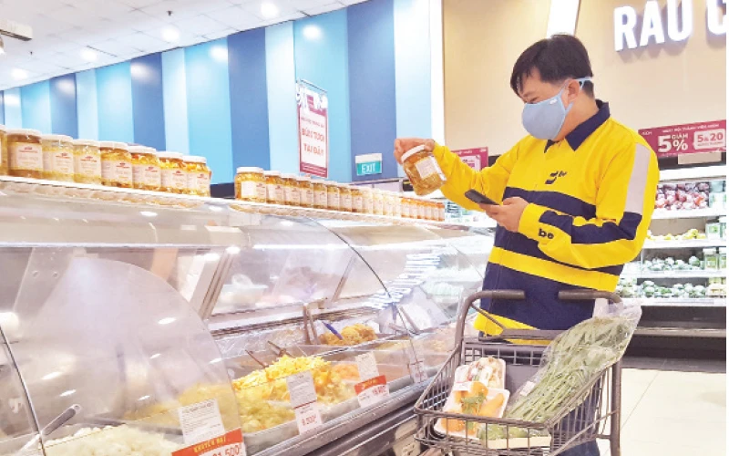 Lái xe công nghệ của Be Group đi chợ theo đơn đặt hàng của người dân qua ứng dụng công nghệ ở một siêu thị tại quận Tân Phú.