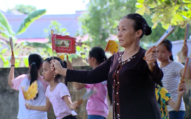 Bà Phạm Thị Gái dạy múa giáo cờ giáo quạt cho trẻ em làng Giắng. Ảnh: HỒNG XOAN