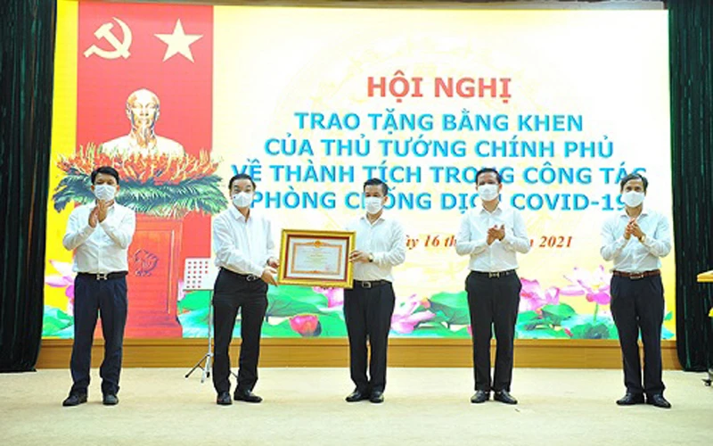 Chủ tịch UBND TP Hà Nội Chu Ngọc Anh trao Bằng khen của Thủ tướng Chính phủ cho nhân dân và cán bộ huyện Đông Anh về thành tích trong công tác phòng, chống dịch Covid-19.