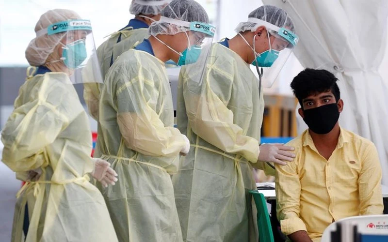 Nhân viên y tế chuẩn bị lấy mẫu xét nghiệm Covid-19 của lao động nhập cư tại Singapore, ngày 15/5/2020. (Ảnh: Reuters)