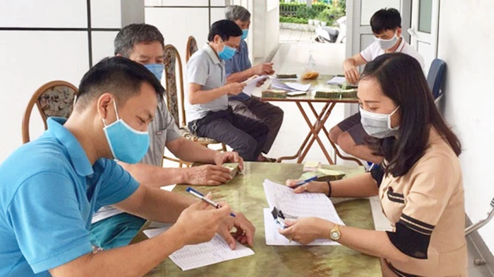 Hỗ trợ cho người dân bị ảnh hưởng bởi dịch Covid-19 tại quận Long Biên. Ảnh: HNM