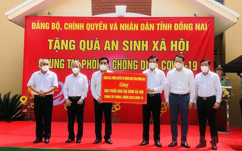 Bí thư Tỉnh ủy Đồng Nai Nguyễn Hồng Lĩnh trao bảng tượng trưng 500 phần quà cho lãnh đạo TP Long Khánh trao đến tận tay người có hoàn cảnh khó khăn.