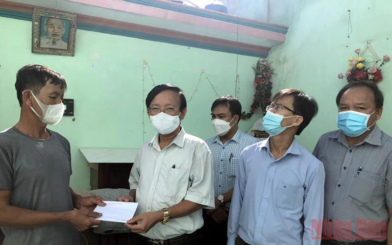 Bí thư Huyện ủy Bình Sơn (Quảng Ngãi) Lương Kim Sơn trao tiền hỗ trợ cho gia đình có nhà bị hư hỏng do lốc xoáy.