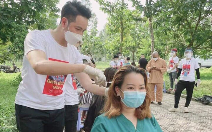 Ca sĩ Nguyễn Phi Hùng hỗ trợ cắt tóc cho các nhân viên y tế trong bệnh viện dã chiến tại TP Hồ Chí Minh. (Ảnh: FB ca sĩ Nguyễn Phi Hùng)