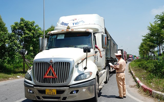 Công an huyện Mê Linh kiểm tra thông tin xe hàng thuộc “luồng xanh” đi từ tỉnh Vĩnh Phúc vào Hà Nội. (Ảnh: Phạm Hùng)