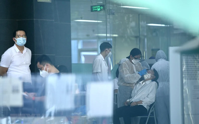 Lực lượng y tế lấy mẫu sàng lọc SARS-CoV-2 cho những người trong tòa D, Bệnh viện Việt Đức chiều 30/9. (Ảnh:TTXVN) 