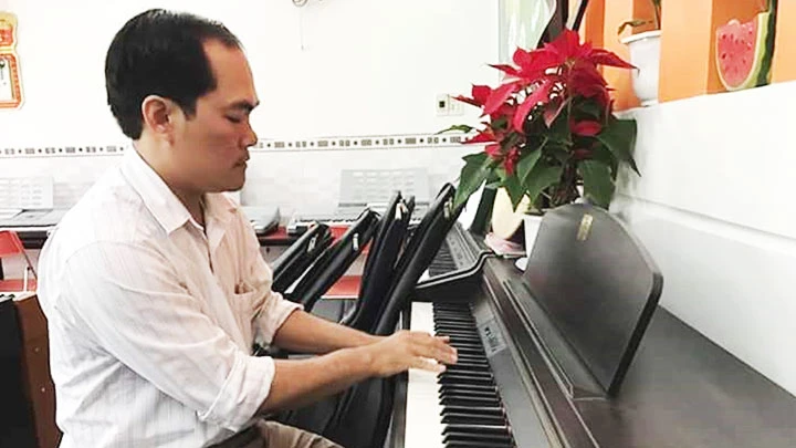 Nhà thơ Lê Hưng Tiến luyện đàn tại nhà.