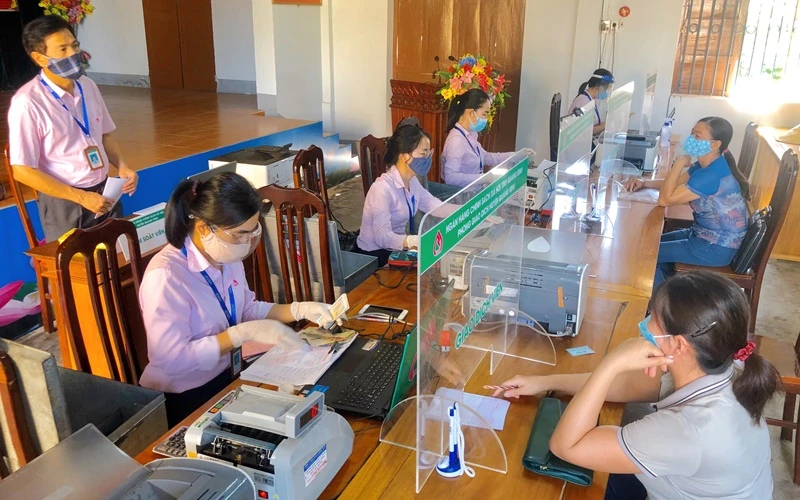 Buổi giao dịch tại xã Vạn Ninh của NHCSXH tỉnh Quảng Bình, các cán bộ luôn thực hiện quy định 5K của Bộ Y tế. (Ảnh: Tuấn Ngọc)