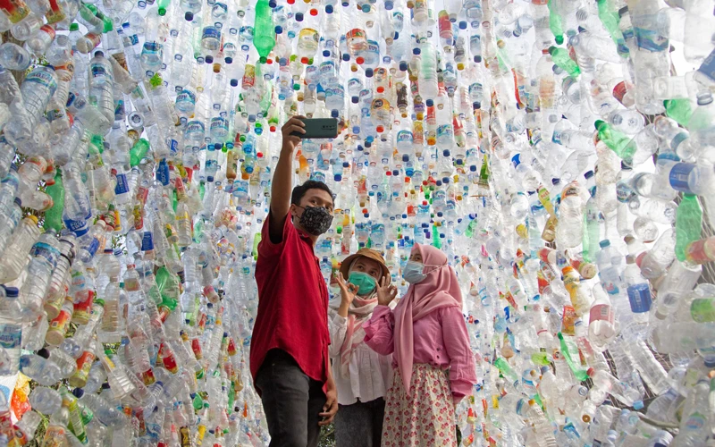 Khách tham quan chụp ảnh trong đường hầm bằng chai nhựa thu từ các con sông trong thành phố trong 3 năm qua. (Ảnh: REUTERS)