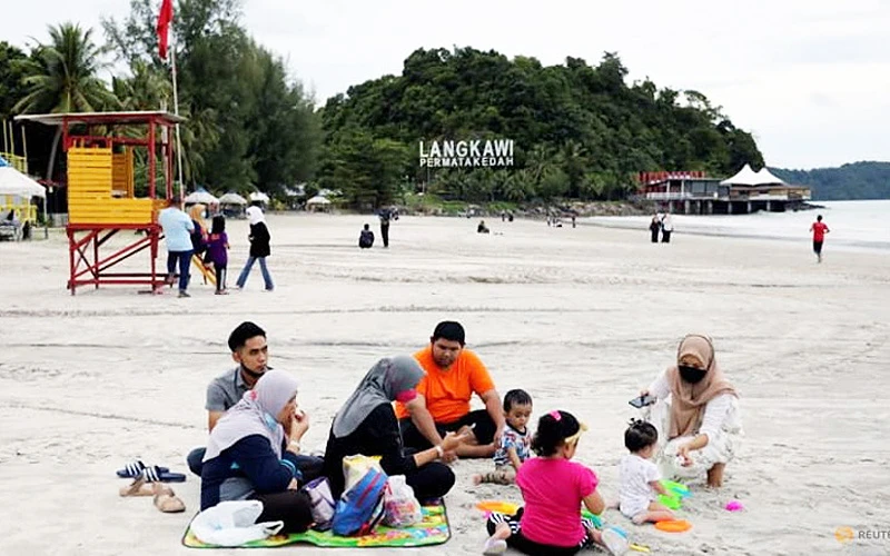 Du khách nghỉ ngơi trên bãi biển ở Langkawi theo mô hình "bong bóng du lịch" (Ảnh: REUTERS)