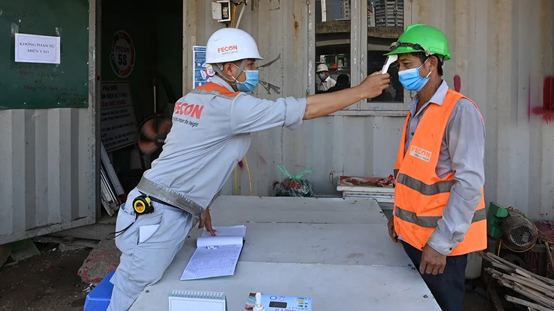 Kiểm tra thân nhiệt, khai báo y tế đối với công nhân tại công trường xây dựng hầm chui nút giao Lê Văn Lương - Khuất Duy Tiến (Hà Nội).