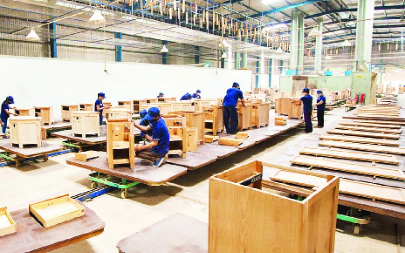Công nhân Công ty cổ phần Công nghiệp và Xuất nhập khẩu cao-su (Rubico) sản xuất gỗ nội thất xuất khẩu.