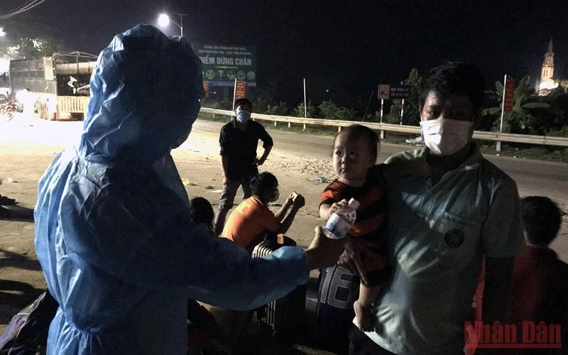Cán bộ trạm kiểm dịch cầu Trì, huyện Bắc Quang (Hà Giang) hỗ trợ lao động từ vùng dịch về quê sáng 8/10. 