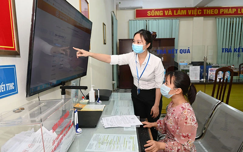 Hướng dẫn người dân thực hiện dịch vụ công trực tuyến tại phường Trung Hòa, quận Cầu Giấy, Hà Nội. Ảnh: Duy Linh