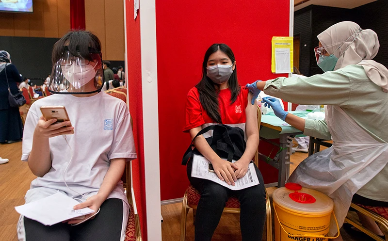 Nhân viên y tế tiêm vắc-xin Covid-19 cho học sinh tại Kuala Lumpur, Malaysia. Ảnh Tân Hoa Xã 