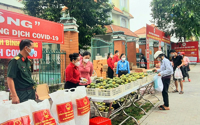 Người dân có hoàn cảnh khó khăn tại phường Phú Hòa, TP Thủ Dầu Một lựa chọn các mặt hàng thiết yếu tại phiên chợ “0 đồng” do Hội Chữ thập đỏ tỉnh Bình Dương tổ chức.Ảnh: HỒNG THUẬN