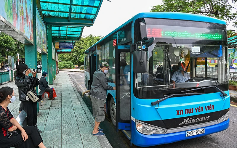 Hành khách đi xe buýt tại trạm trung chuyển xe buýt Long Biên. Ảnh: MINH HÀ
