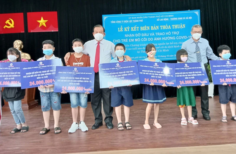 Đại diện Sở Lao động, Thương binh và Xã hội TP Hồ Chí Minh và EVNHCMC trao hỗ trợ cho học sinh mồ côi cha, mẹ trong dịch Covid-19.
