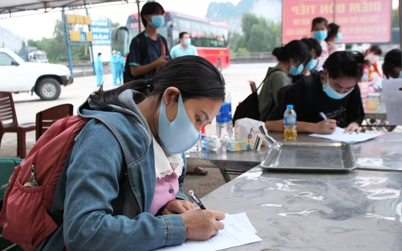 Công nhân hồi hương khai báo y tế tại điểm đón, tiếp ở xã Trường Lâm, thị xã Nghi Sơn.