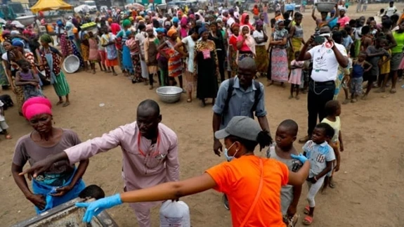 Người dân Ghana xếp hàng nhận đồ cứu trợ trong giai đoạn một số thành phố bị phong tỏa để hạn chế đại dịch lây lan. Ảnh: Reuters