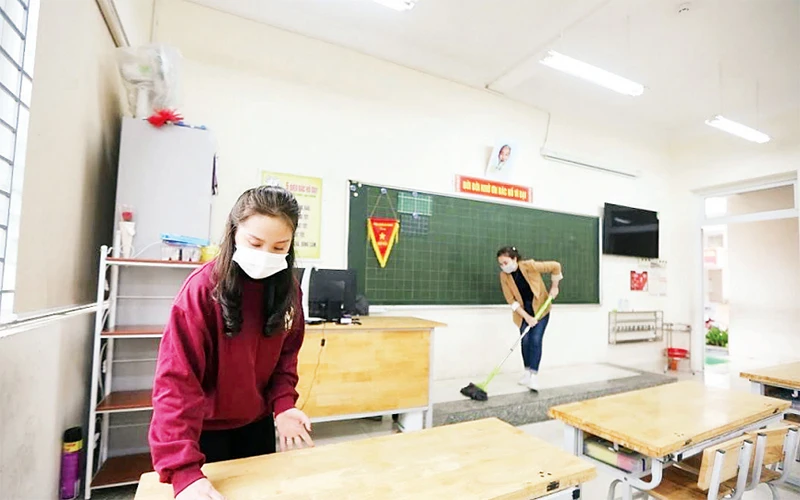 Giáo viên Trường tiểu học Xuân Phương (quận Nam Từ Liêm) vệ sinh phòng học, chuẩn bị đón học sinh trở lại trường. Ảnh: NAM NGUYỄN