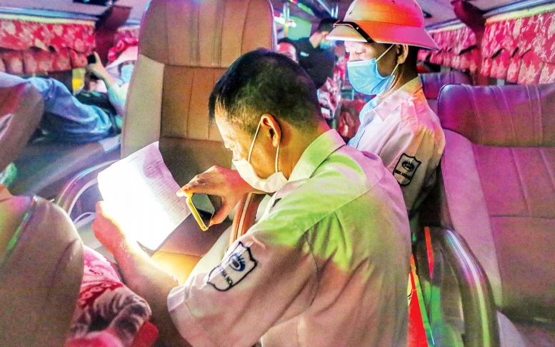 Nhân viên bến xe Mỹ Ðình kiểm tra danh sách hành khách trên tuyến Hà Nội - Cao Bằng. Ảnh: TUẤN ÐỨC