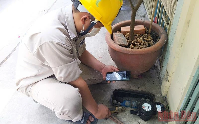 Nhân viên một Công ty cổ phần cấp nước tại TP Hồ Chí Minh kiểm tra đồng hồ nước tại nhà dân.