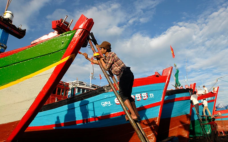 Ngư dân tỉnh Quảng Ngãi sơn sửa tàu thuyền, chuẩn bị cho chuyến ra khơi đánh bắt hải sản. Ảnh: NGUYỄN ĐĂNG