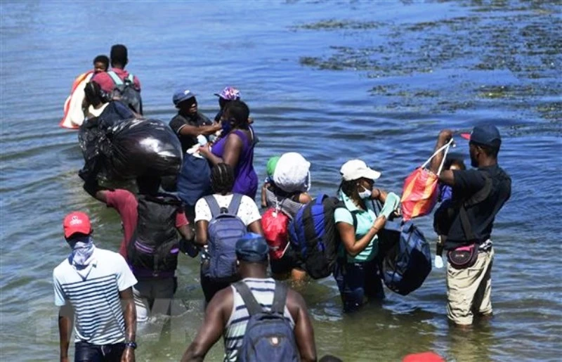 Người di cư băng qua sông ở bang Coahuila, Mexico. (Ảnh: AFP/TTXVN)