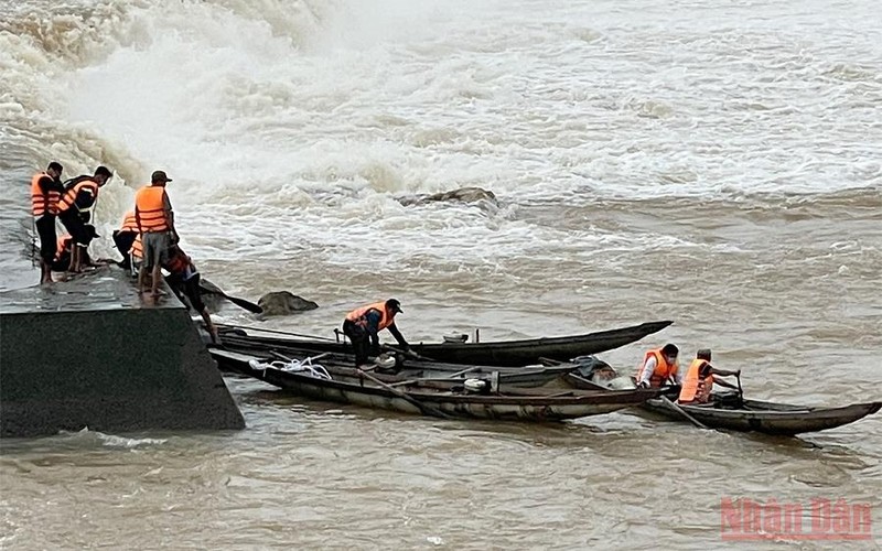 Thuyền cứu hộ tiếp cận đưa người mắc kẹt lên bờ. Những người mắc kẹt được cứu hộ an toàn. (Ảnh: LÂM QUANG HUY) 