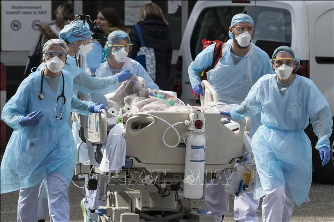 Nhân viên y tế chuyển bệnh nhân nhiễm Covid-19 tới một bệnh viện ở Mulhouse, Pháp ngày 22/3/2020. Ảnh: AFP/TTXVN