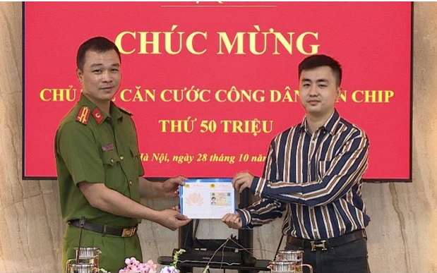 Thượng tá Tô Anh Dũng, Phó Cục trưởng Cảnh sát quản lý hành chính về trật tự xã hội tặng chiếc thẻ thứ 50 triệu cho công dân Trần Quang Huy.