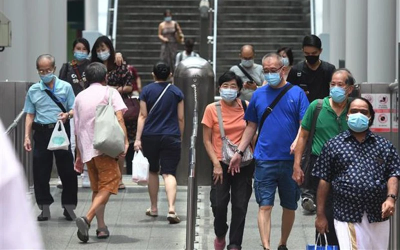 Người dân đeo khẩu trang phòng lây nhiễm Covid-19 tại ga tàu điện ngầm ở Singapore. (Ảnh: THX/TTXVN)