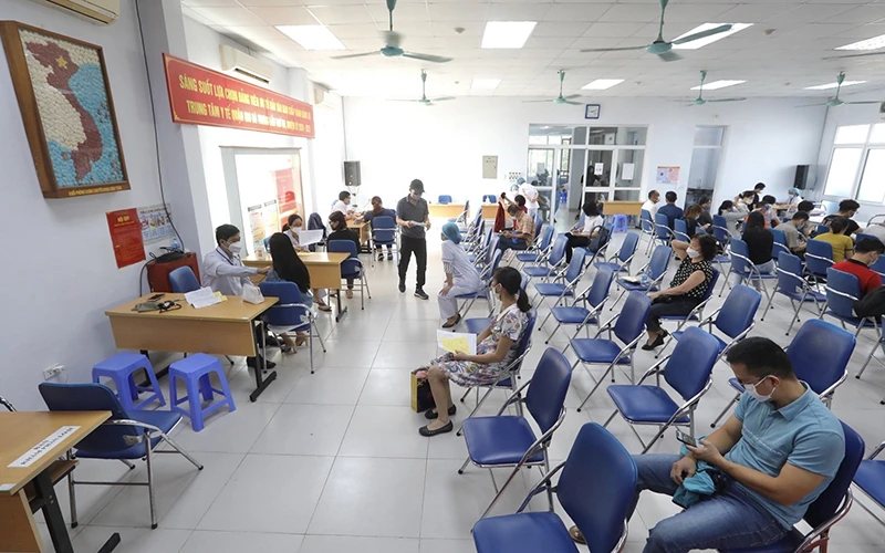 Người dân đến tiêm vắc-xin phòng Covid-19 tại điểm tiêm chủng quận Hai Bà Trưng (Hà Nội). Ảnh TTXVN