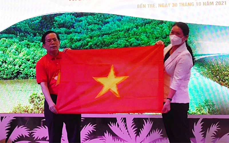 Phó Chủ tịch UBND tỉnh Bến Tre Nguyễn Thị Bé Mười nhận tượng trưng 10 nghìn lá cờ Tổ quốc từ lãnh đạo báo Người Lao Động.