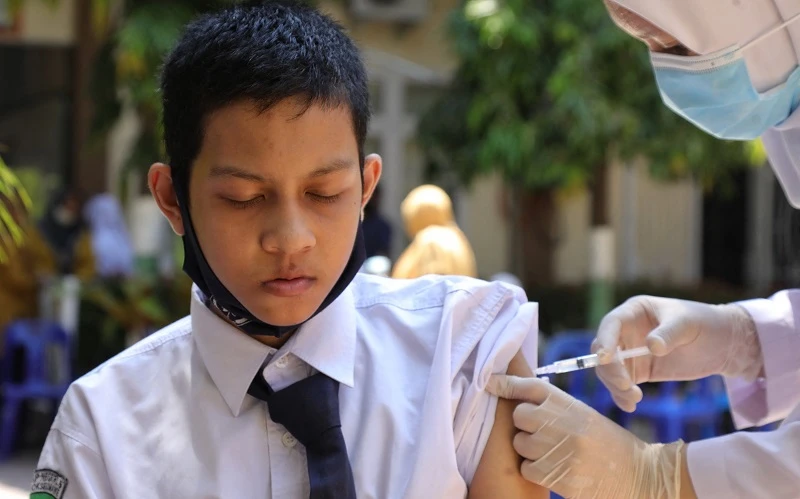 Nhân viên y tế tiêm vaccine ngừa Covid-19 cho học sinh tại tỉnh Aceh, Indonesia. (Ảnh: AFP/TTXVN)