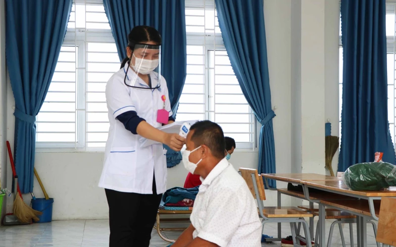 Nhân viên y tế đo thân nhiệt cho F0 tại khu cách ly tập trung huyện Thuận Nam ( Ninh Thuận).