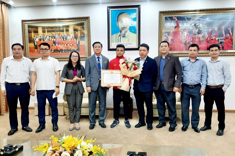 Đại diện lãnh đạo Ủy ban Dân tộc trao bằng khen và phần thưởng cho cầu thủ Hồ Thanh Minh. (Ảnh: VFF)