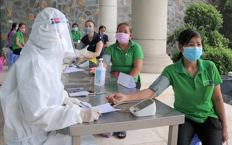 Khám sàng lọc trước khi tiêm vắc-xin phòng Covid-19 cho người lao động trong khu công nghiệp tại tỉnh Đồng Nai.