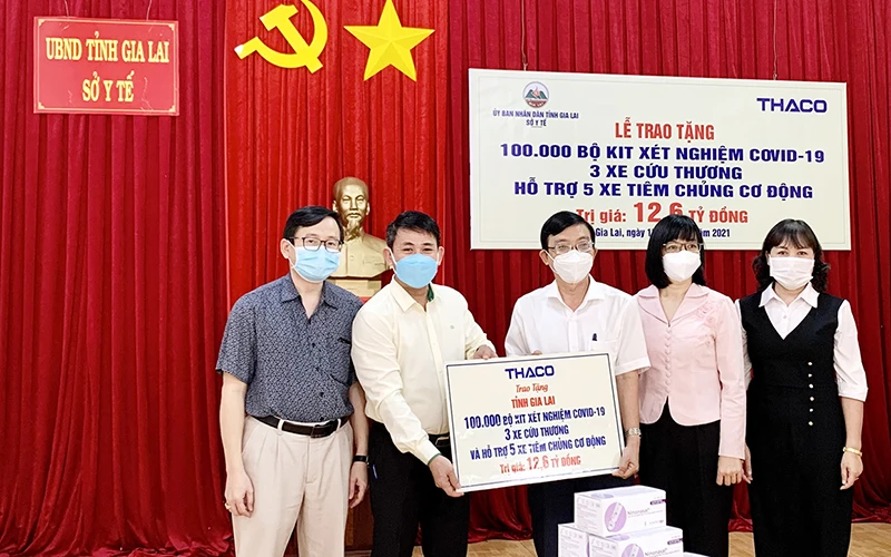 Đại diện THACO trao bảng tượng trưng hỗ trợ cho tỉnh Gia Lai. (Ảnh: Như Nguyện)